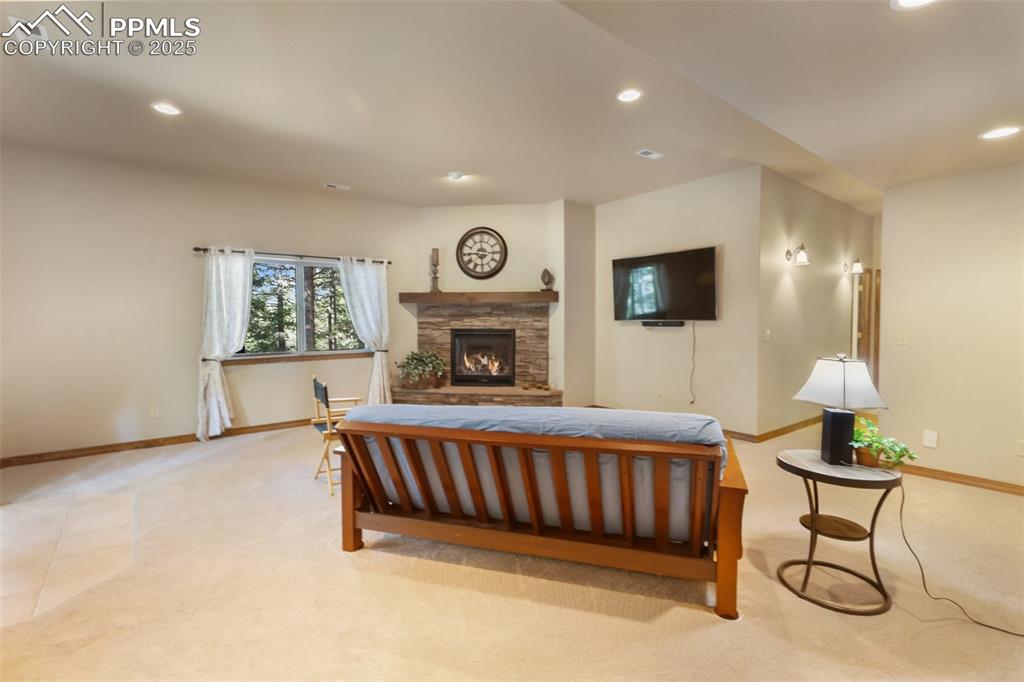 Image 21 of 43: Living area featuring light colored carpet, recessed lighting, and a stone 