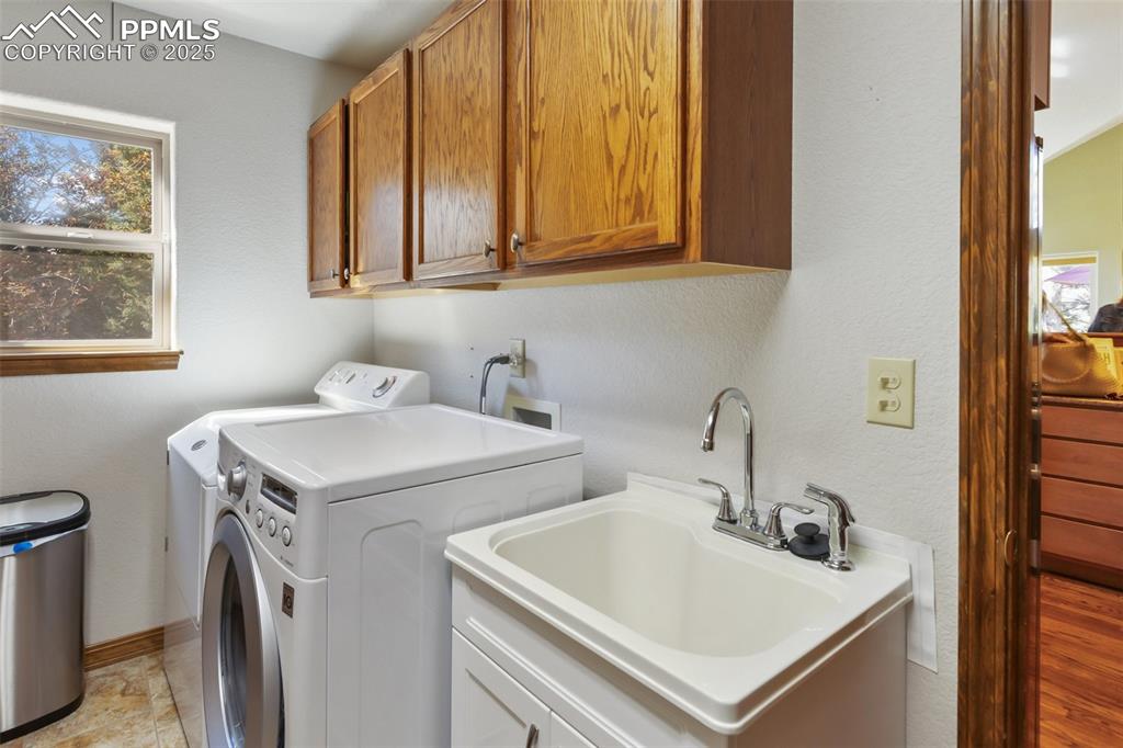 Image 25 of 43: Laundry room with washing machine and clothes dryer and cabinet space
