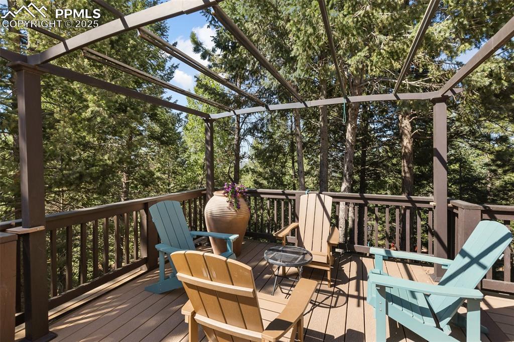 Image 27 of 43: Wooden terrace featuring view of scattered trees