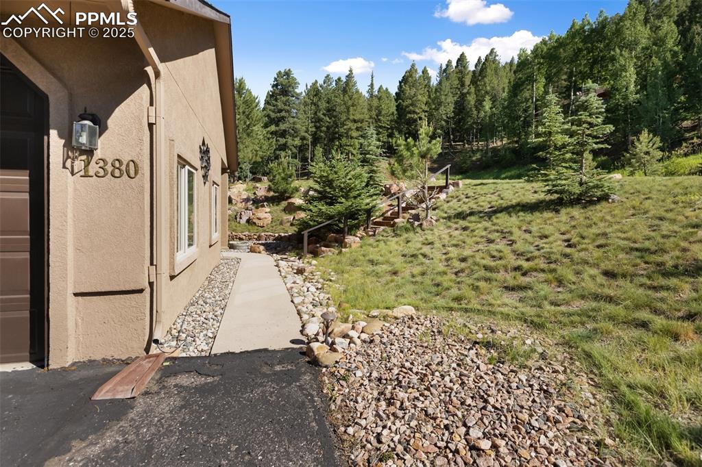 Image 3 of 43: View of side of property with stucco siding and a yard