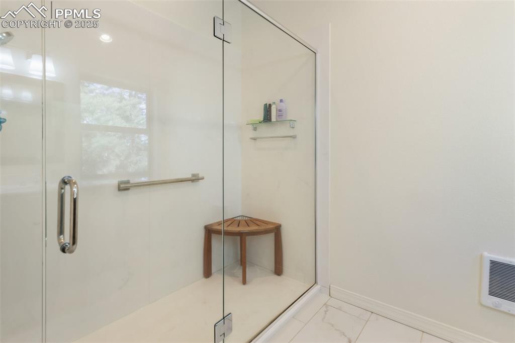 Image 33 of 43: Full bathroom featuring a shower stall and marble look tile flooring