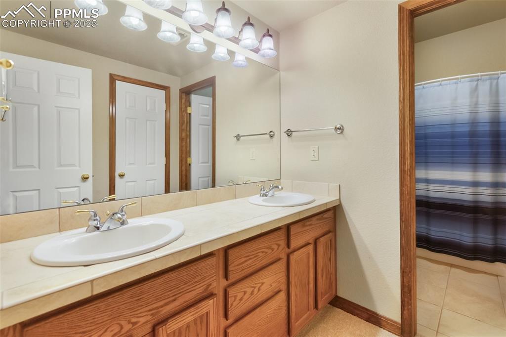 Image 36 of 43: Bathroom featuring double vanity and tile patterned floors