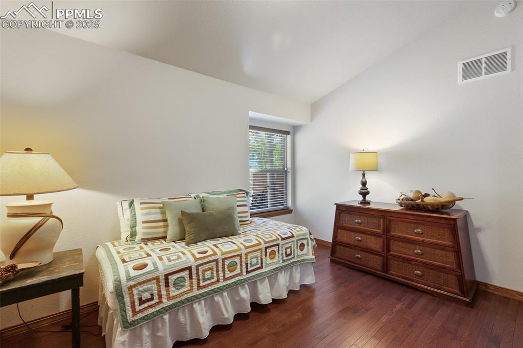 Image 39 of 43: Bedroom with dark wood-type flooring and vaulted ceiling