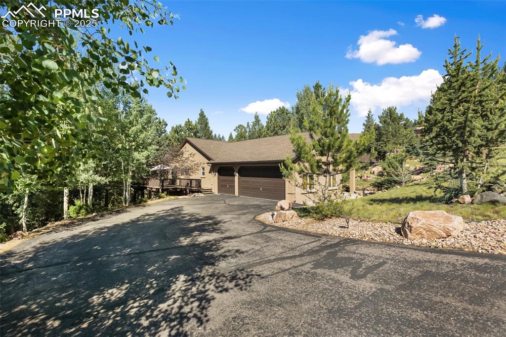 Image 4 of 43: View of front facade featuring asphalt driveway, a garage, and a deck