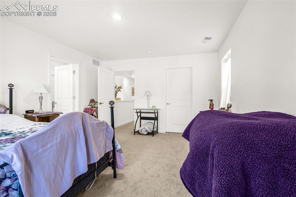 Image 13 of 27: Bedroom featuring visible vents, baseboards, and light colored carpet