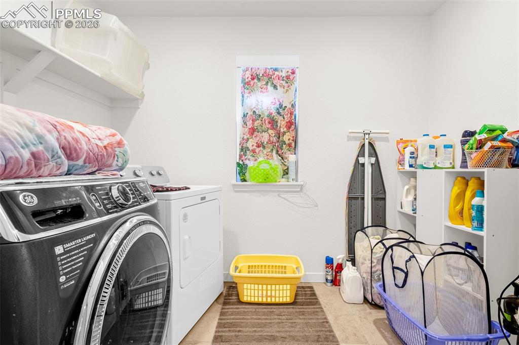 Image 16 of 27: Clothes washing area featuring washer and clothes dryer, laundry area, and 