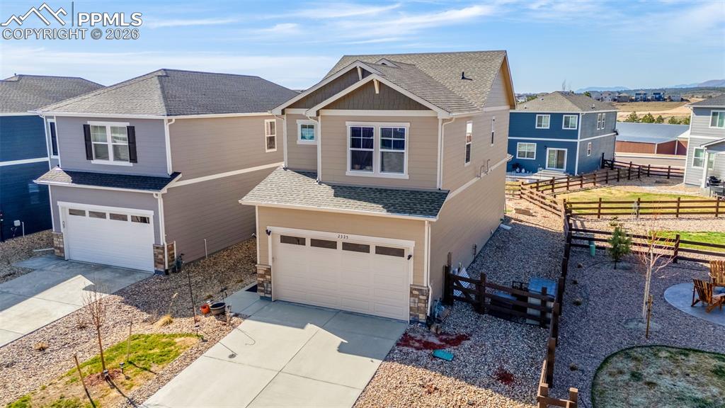 Image 18 of 27: View of front of property with an attached garage, a shingled roof, drivewa