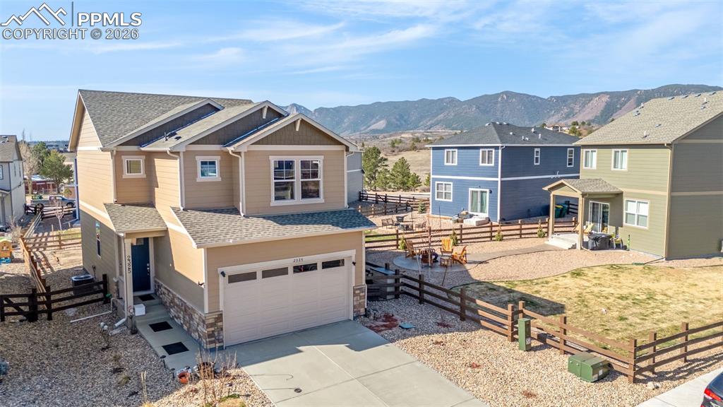 Image 19 of 27: View of front of home featuring a mountain view, driveway, an attached gara