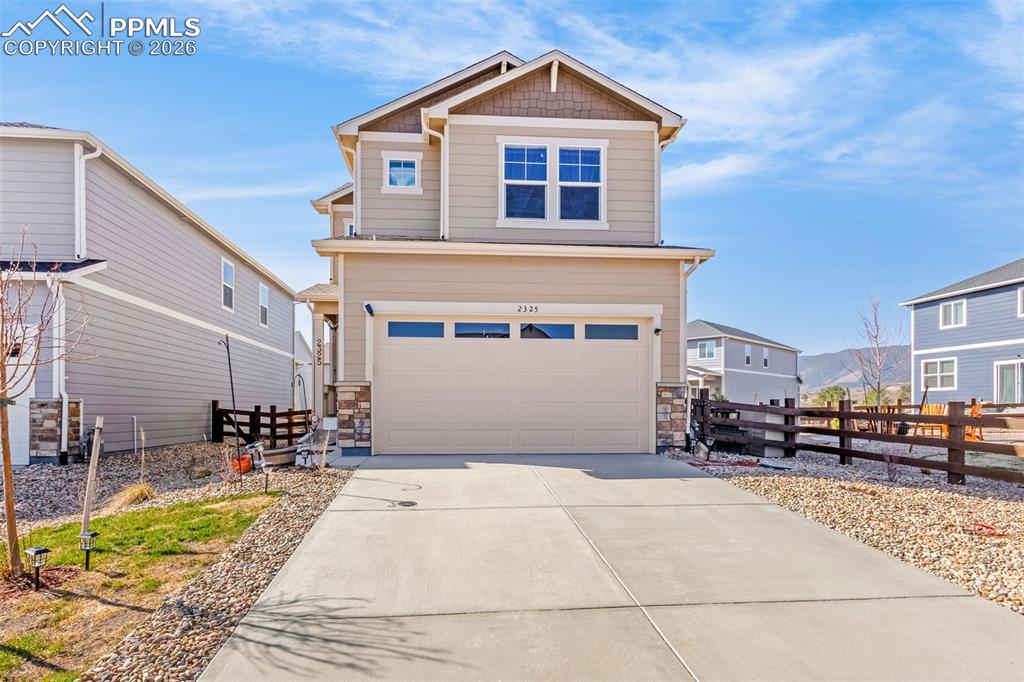 Image 2 of 27: Craftsman inspired home featuring driveway, a garage, stone siding, and fen