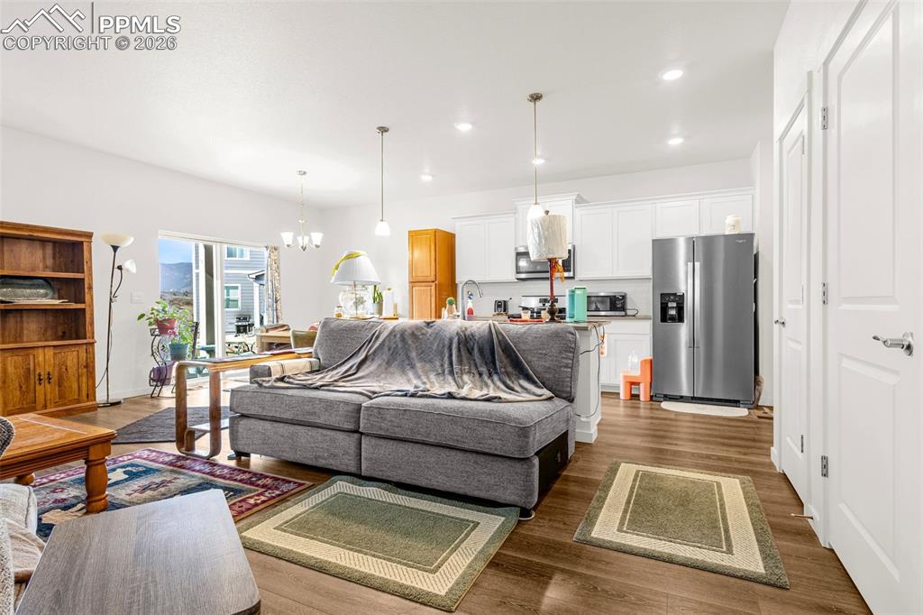 Image 4 of 27: Living room featuring recessed lighting, a notable chandelier, and wood fin