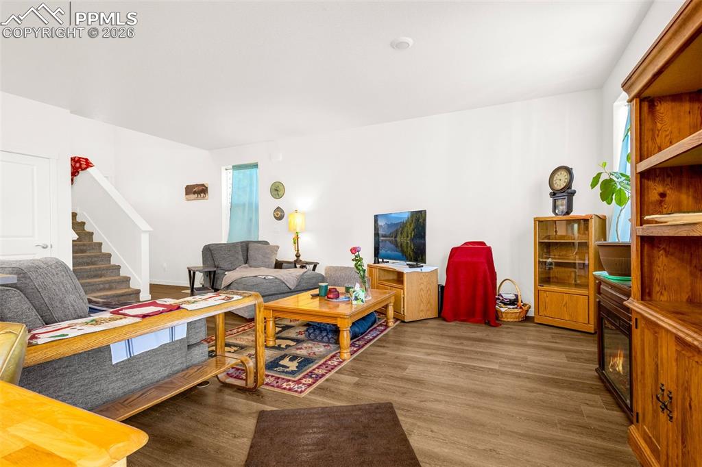 Image 5 of 27: Living area with wood finished floors and stairway