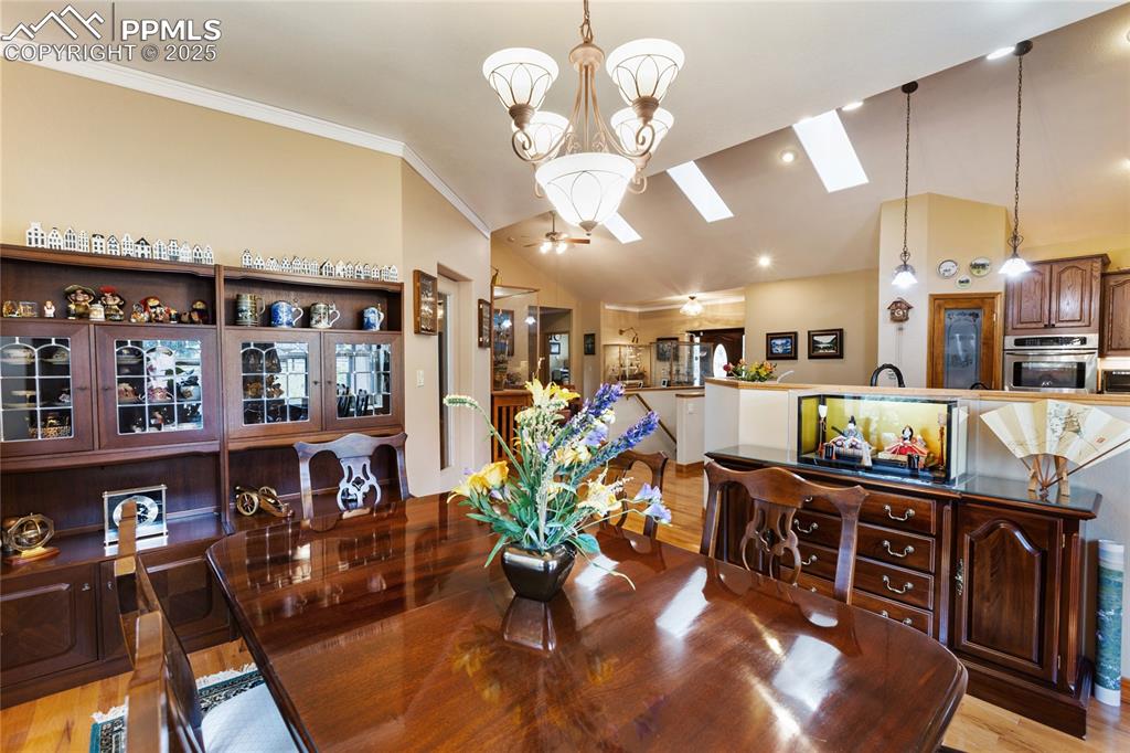 Image 12 of 47: Dining room featuring light wood-type flooring, a chandelier, crown molding