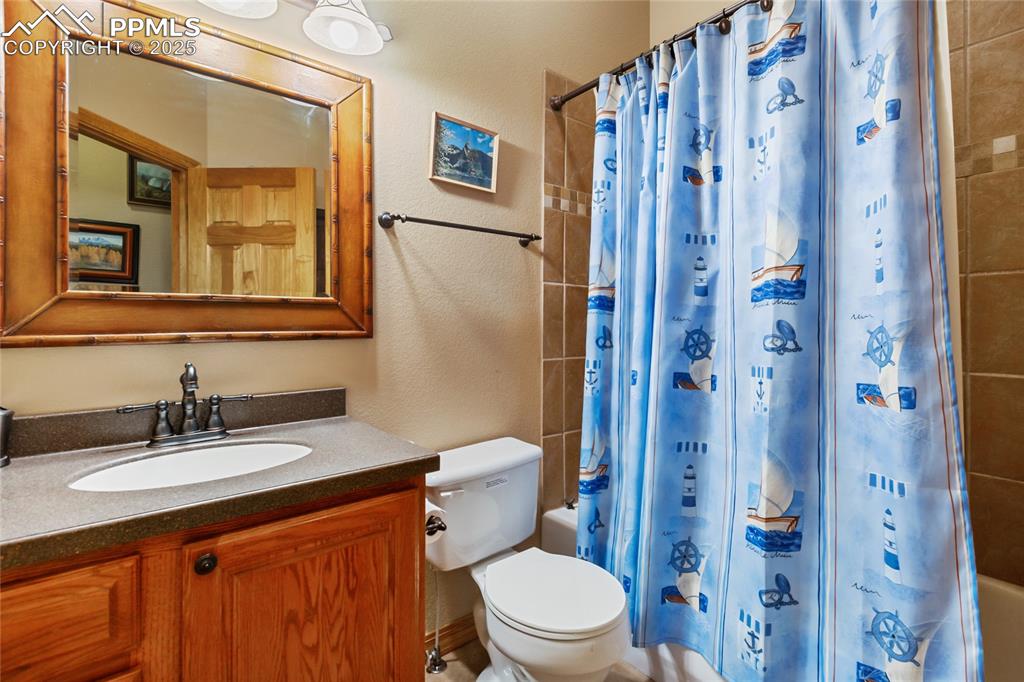 Image 36 of 47: Bathroom with vanity, shower / bath combo with shower curtain.
