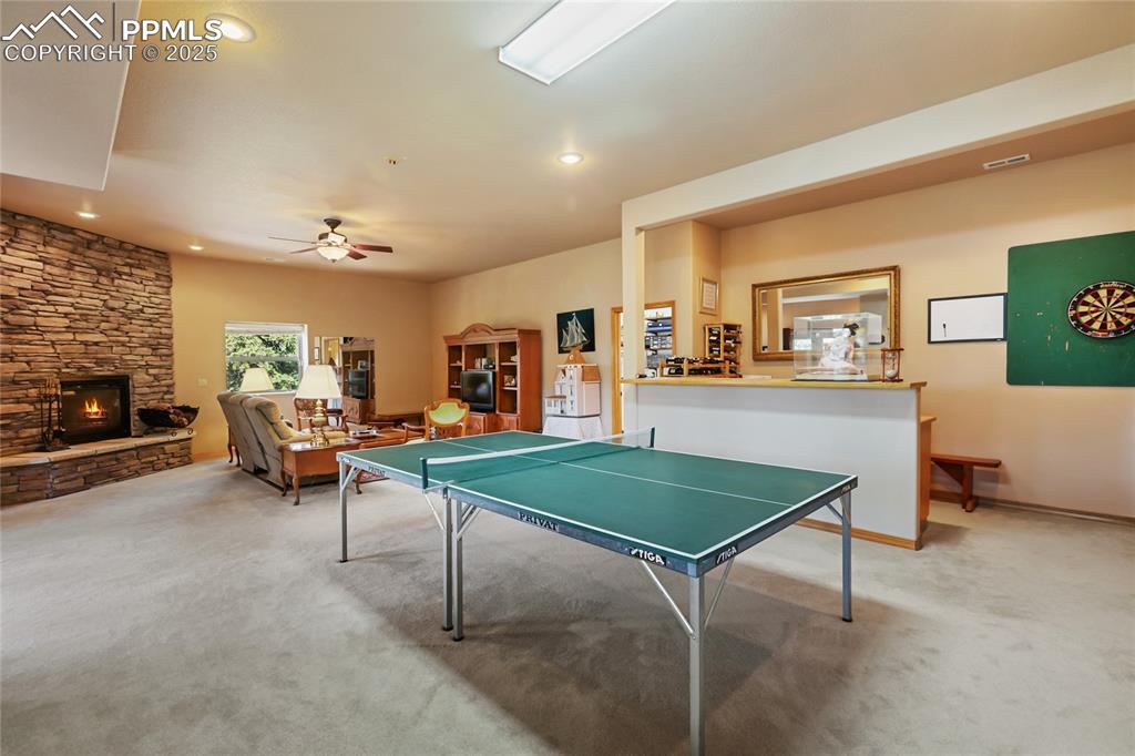 Image 37 of 47: The rec room features carpet floors, a ceiling fan, recessed lighting, and