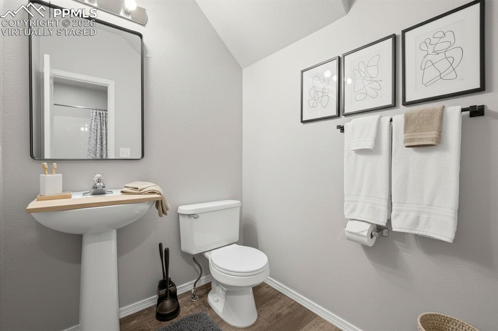 Image 13 of 33: Half bath on main floor. This photo is virtually staged.