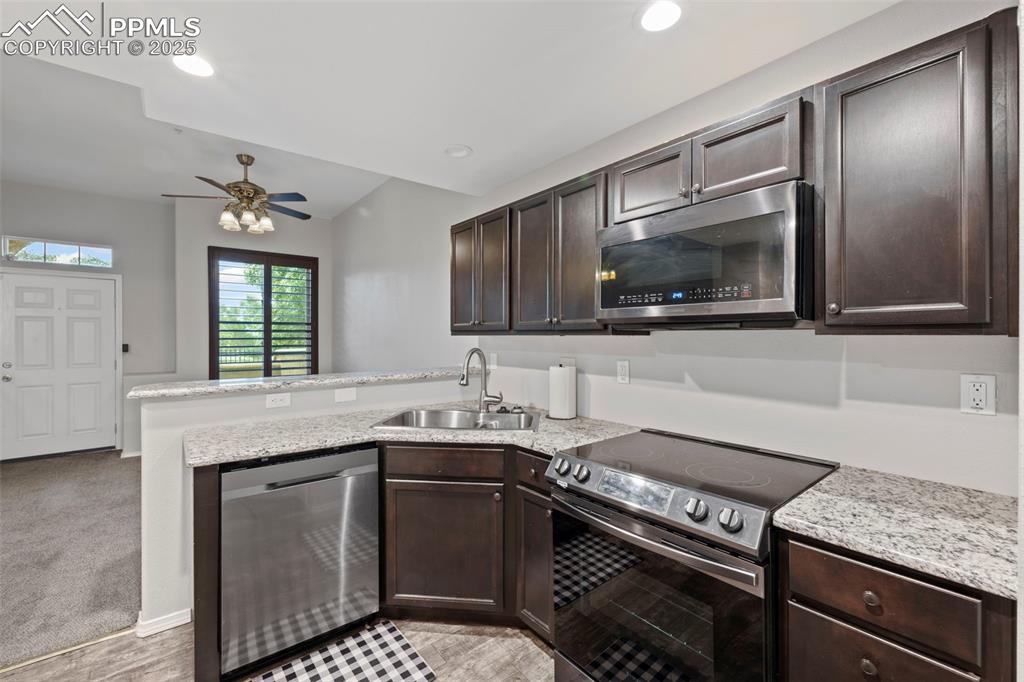 Image 14 of 23: Kitchen featuring appliances with stainless steel finishes, a sink, a penin