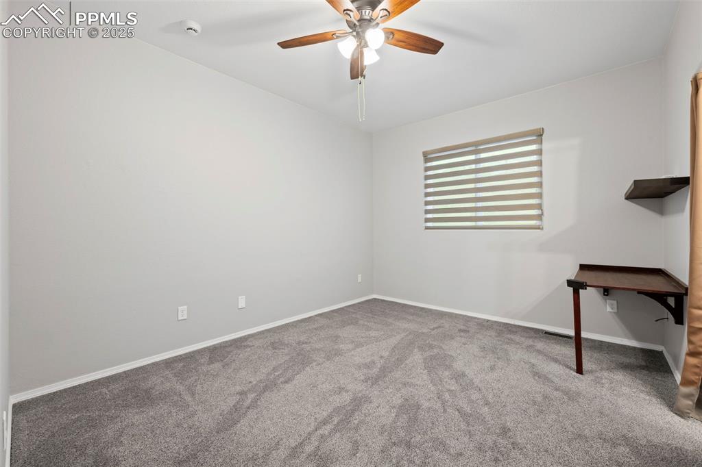 Image 16 of 23: Spare room featuring carpet floors, ceiling fan, baseboards, and a smoke de