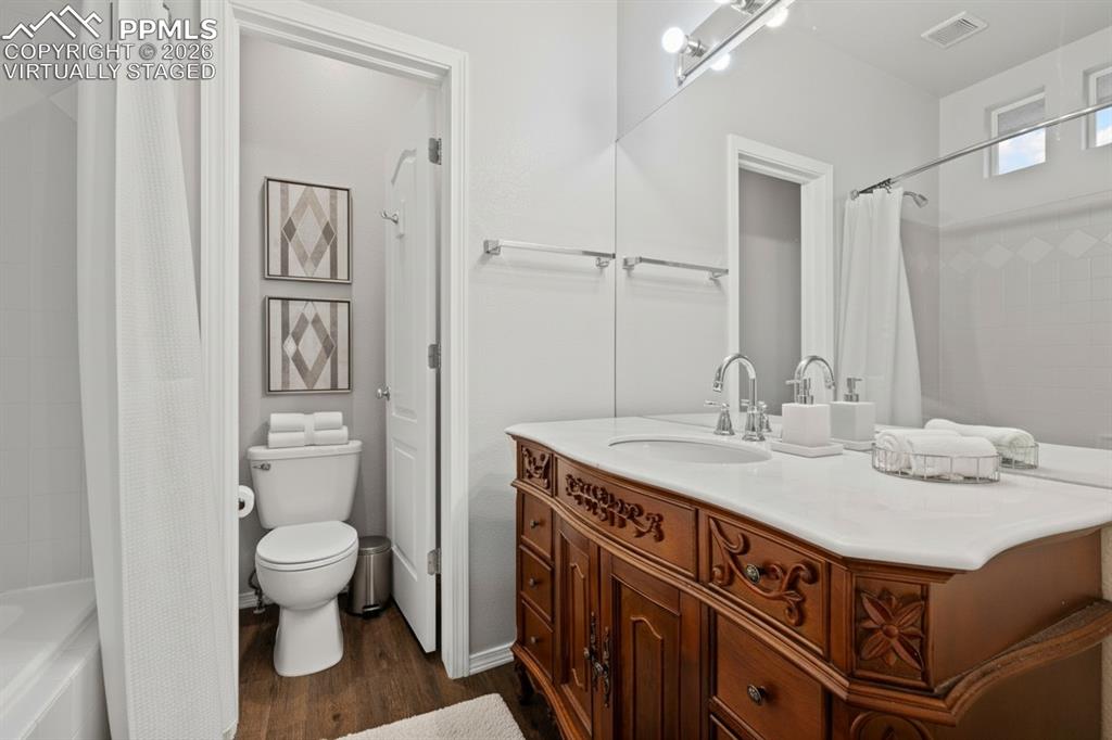 Image 16 of 33: Full bath with a bathtub, wood-like floor. This photo is virtually staged.