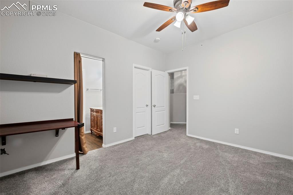 Image 17 of 23: Unfurnished bedroom with carpet, baseboards, ensuite bathroom, and a ceilin