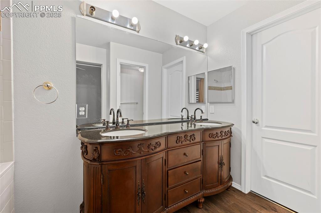 Image 22 of 23: Full bath featuring double vanity and wood finished floors