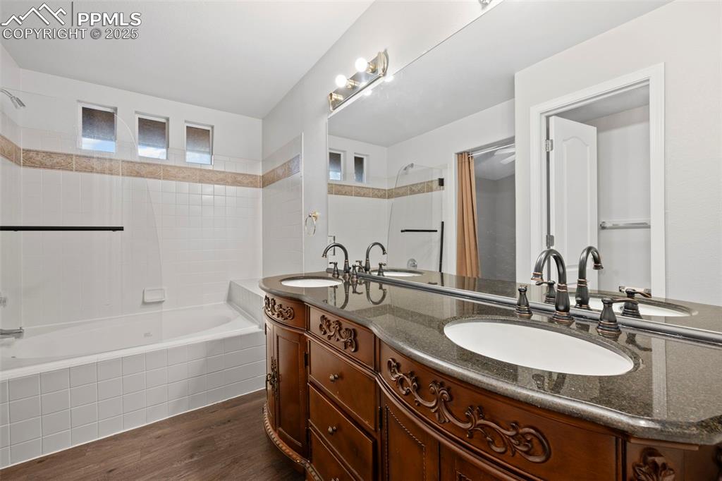 Image 23 of 23: Bathroom with double vanity, shower / bathtub combination with curtain, and