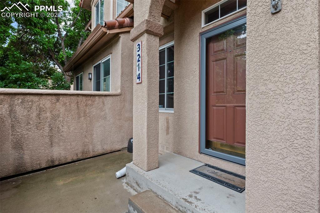 Image 5 of 33: Property entrance with stucco siding