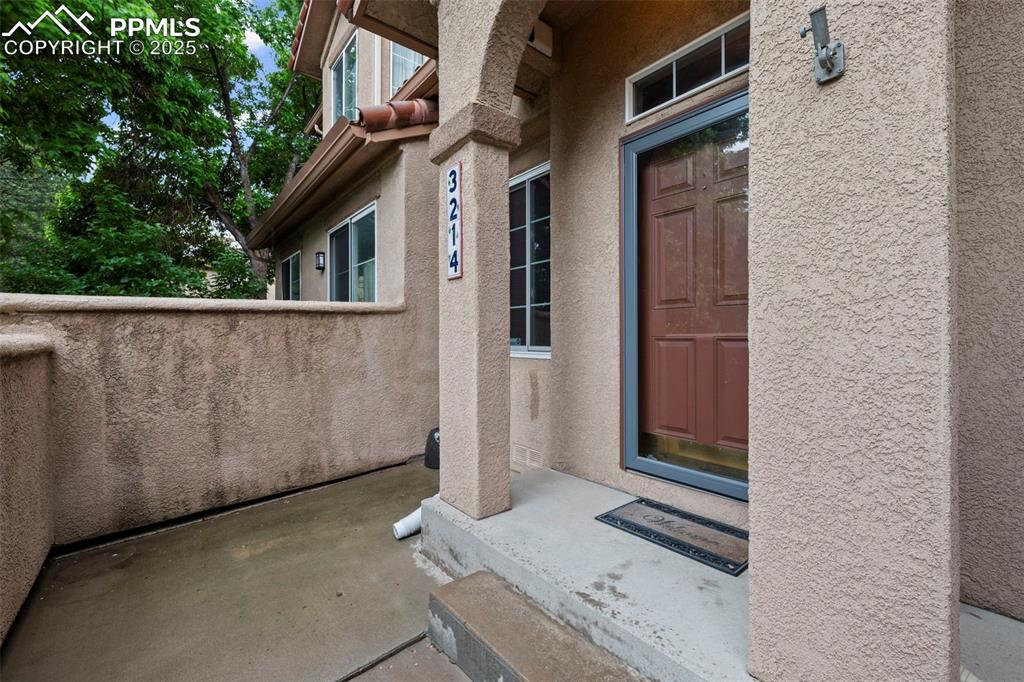 Image 6 of 33: Property entrance with stucco siding