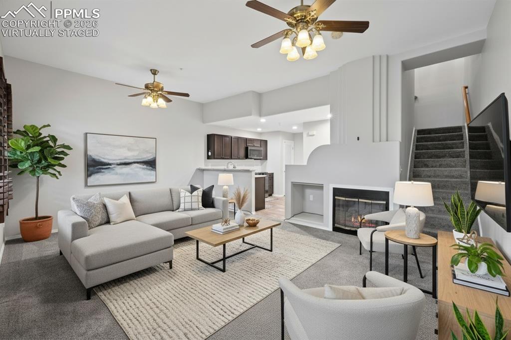 Image 8 of 33: Living room featuring custom window shutters, a ceiling fan, carpet floorin
