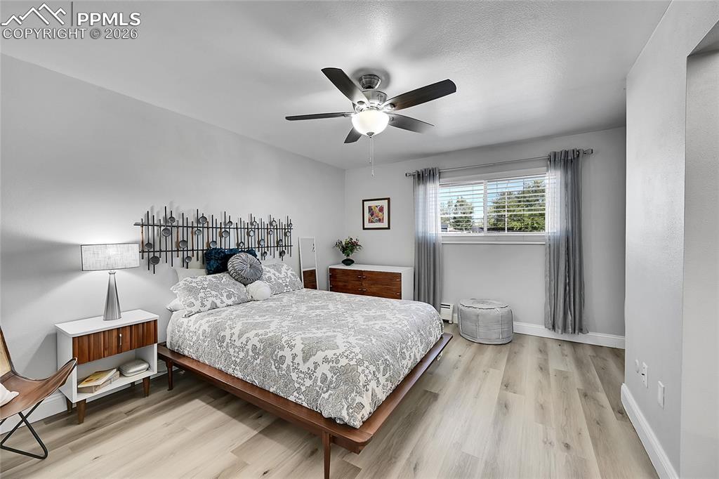 Image 12 of 42: Bedroom with light hardwood / wood-style floors, a baseboard heating unit, 