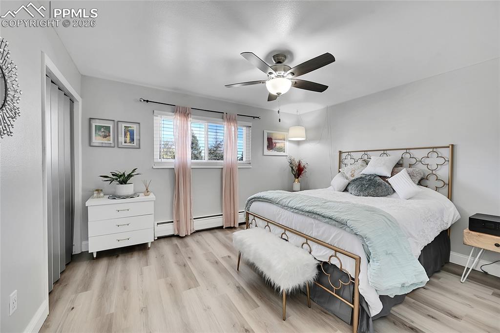 Image 18 of 42: Bedroom featuring a closet, a baseboard heating unit, light wood-type floor