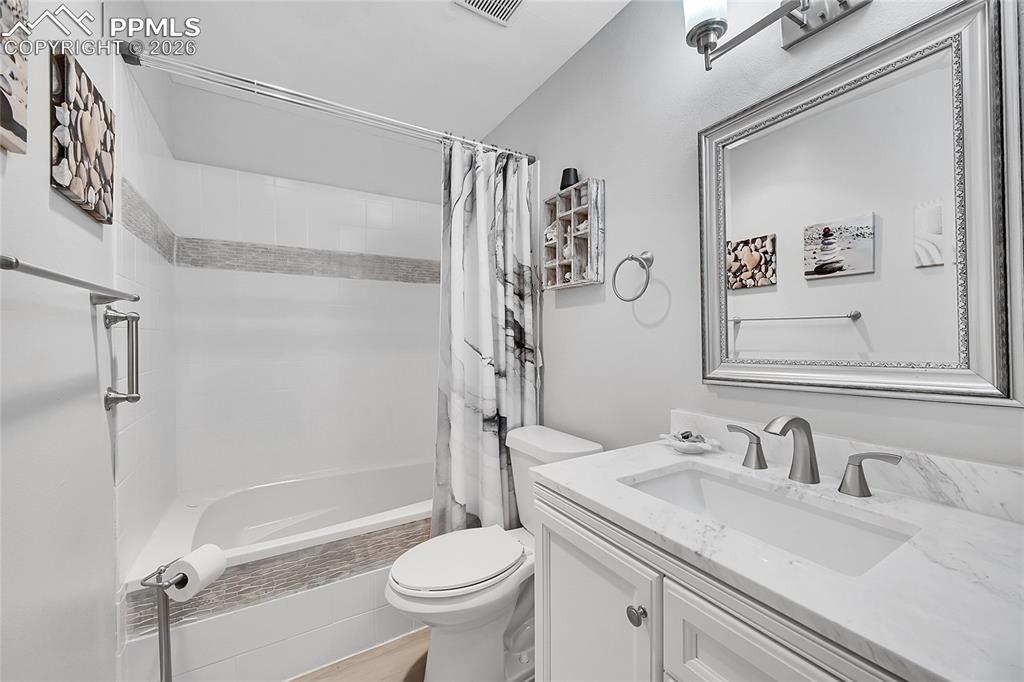 Image 20 of 42: Full bathroom featuring toilet, shower / bath combo with shower curtain, an