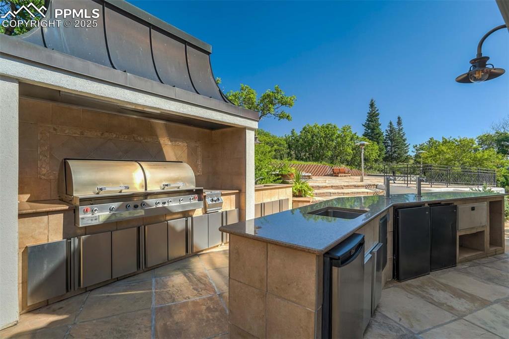 Image 10 of 50: View of patio / terrace featuring an outdoor kitchen