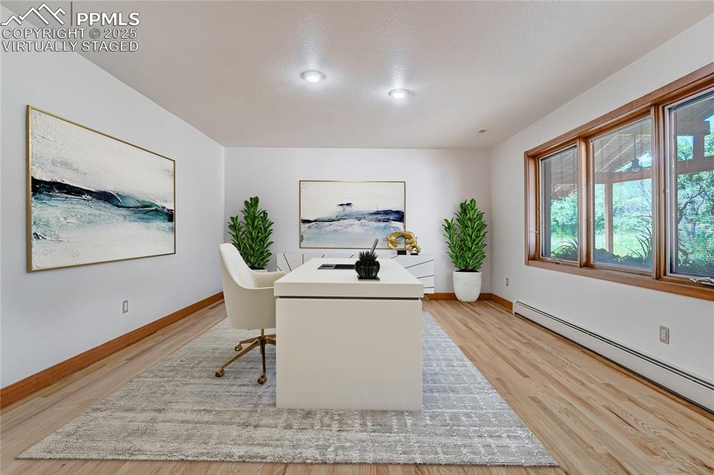 Image 16 of 50: Office area with light wood-type flooring and baseboard heating, virtually 