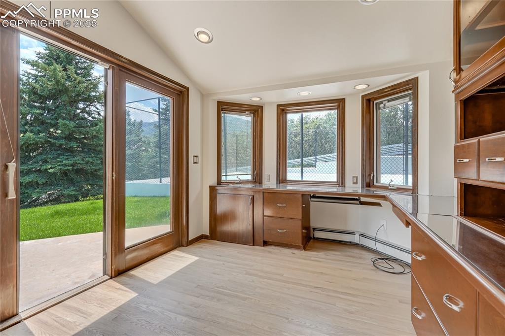 Image 27 of 50: Doorway with built in desk, recessed lighting, lofted ceiling, wood finishe