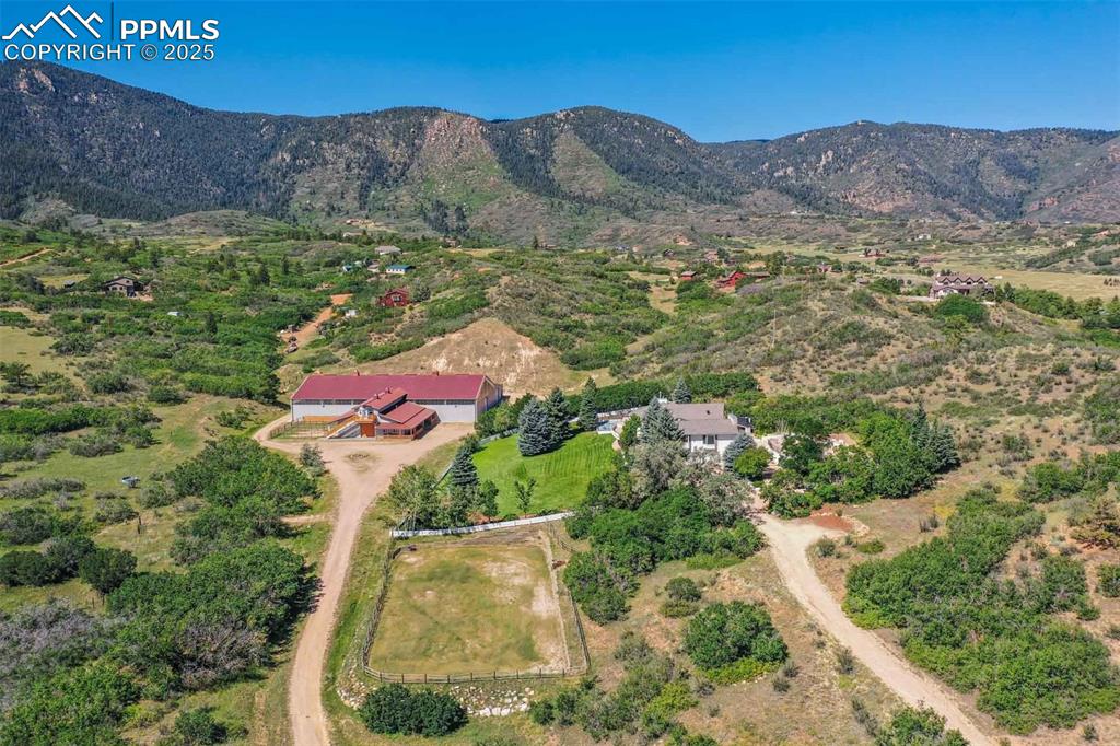 Image 41 of 50: Aerial view of property and surrounding area featuring a mountainous backgr