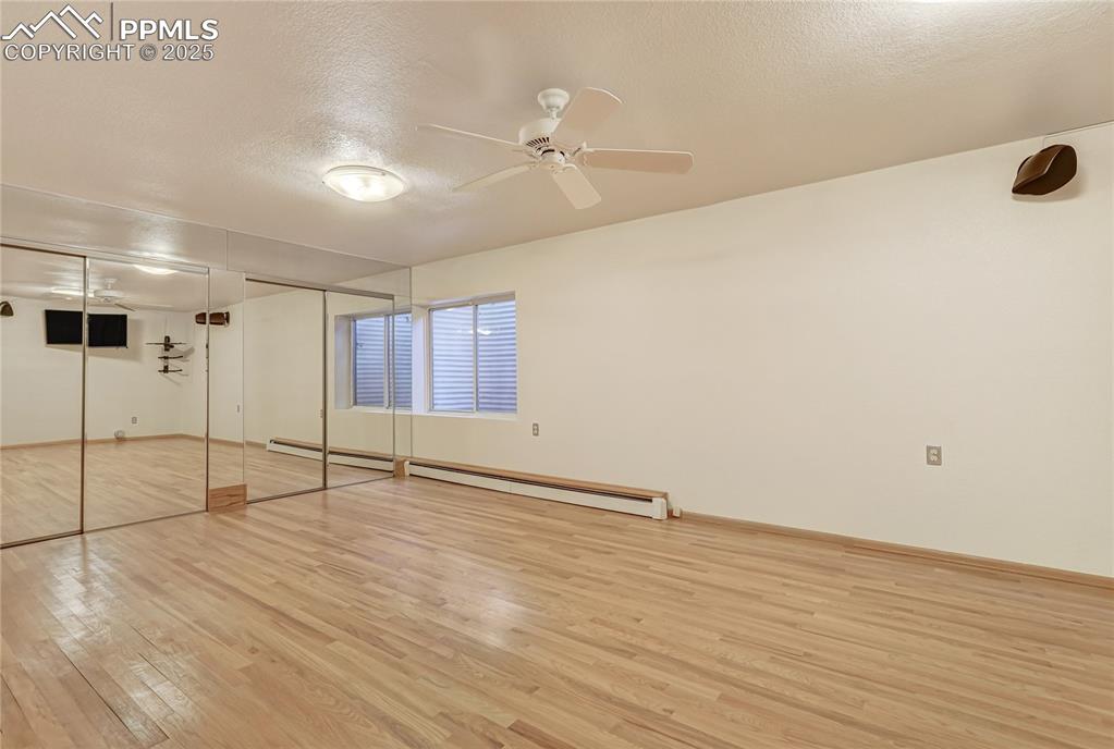 Image 43 of 50: Unfurnished bedroom featuring wood-type flooring, a textured ceiling, a clo
