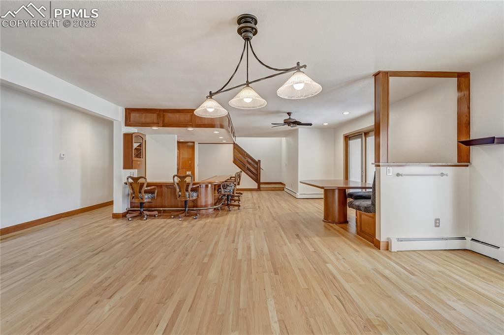 Image 45 of 50: Kitchen featuring light wood-style floors, hanging light fixtures, brown ca