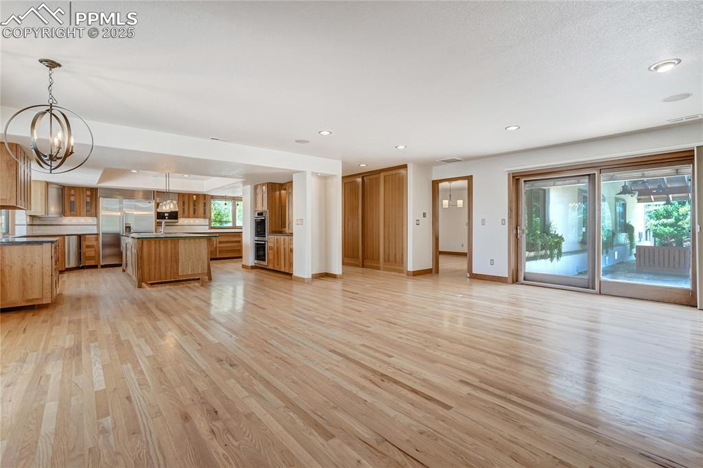 Image 49 of 50: Kitchen with a kitchen island, a chandelier, light wood-type flooring, open