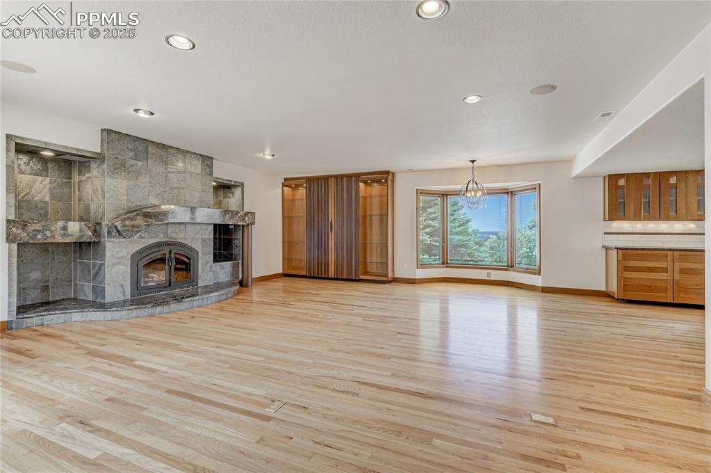 Image 6 of 50: Unfurnished living room featuring a fireplace, light wood-type flooring, re