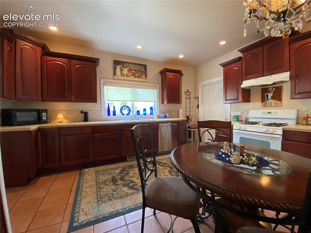 Image 6 of 25: With updated cabinets and tile countertops, the kitchen provides ample stor