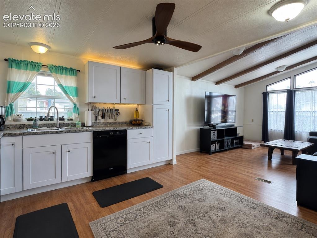 Image 13 of 34: Open-concept interior featuring light wood-finish flooring, exposed ceiling