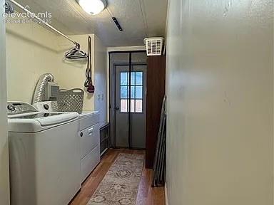 Image 20 of 34: Dedicated laundry space featuring wood-finish flooring, light-toned walls, 