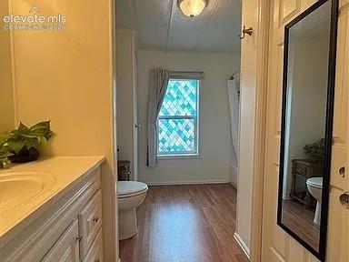 Image 25 of 34: Bathroom with wood-finish flooring and a decorative window