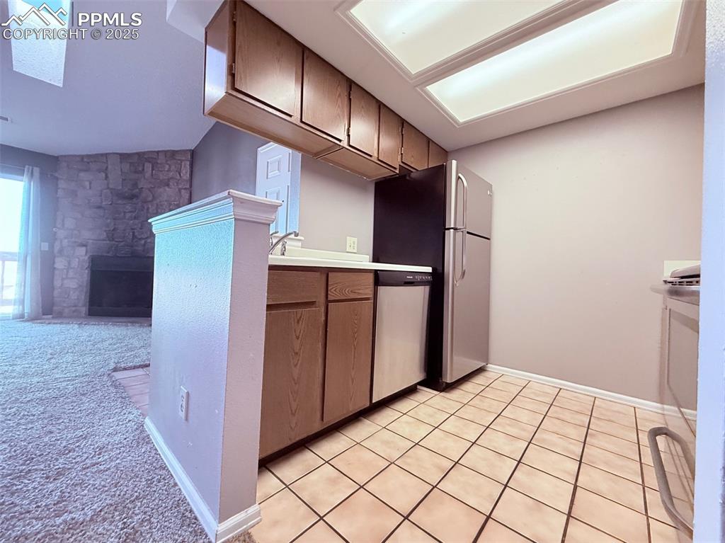 Image 11 of 35: Kitchen with light countertops, appliances with stainless steel finishes, l