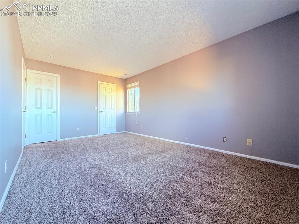 Image 17 of 35: Unfurnished bedroom with carpet flooring, a textured ceiling, and a closet