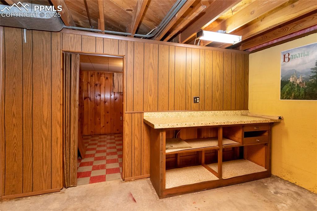 Image 16 of 24: Basement with light flooring and wooden walls