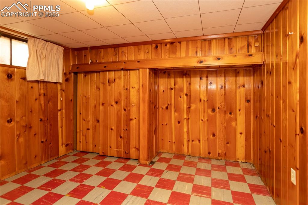 Image 17 of 24: Finished below grade area featuring light flooring and wood walls