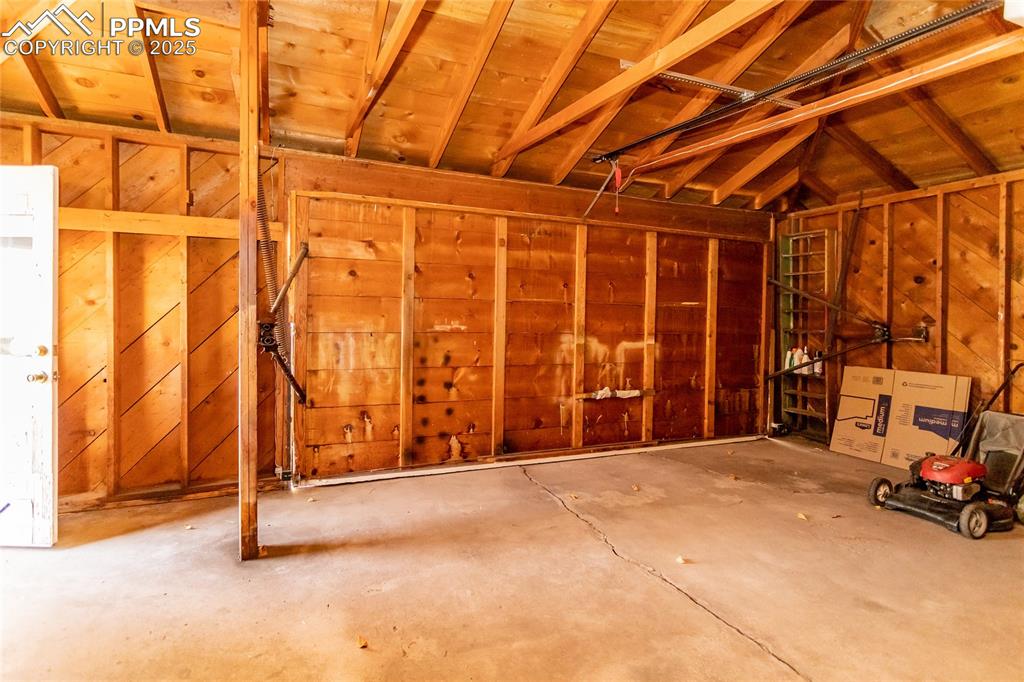 Image 21 of 24: Garage with wooden walls and wood ceiling