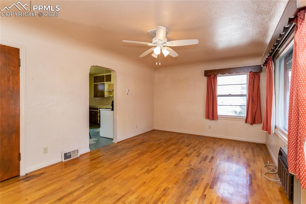 Image 5 of 24: Empty room featuring arched walkways, light wood finished floors, ceiling f