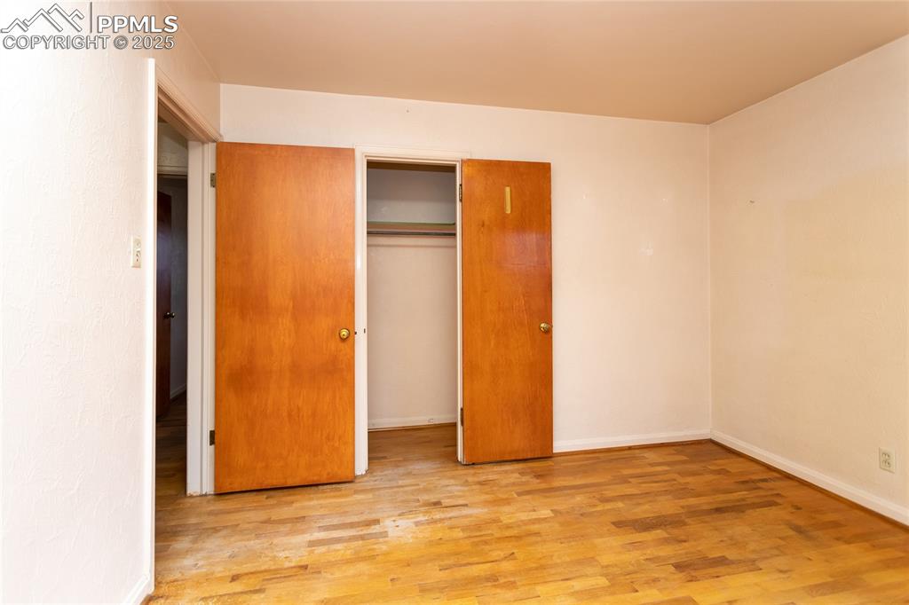 Image 7 of 24: Unfurnished bedroom with light wood finished floors and a closet